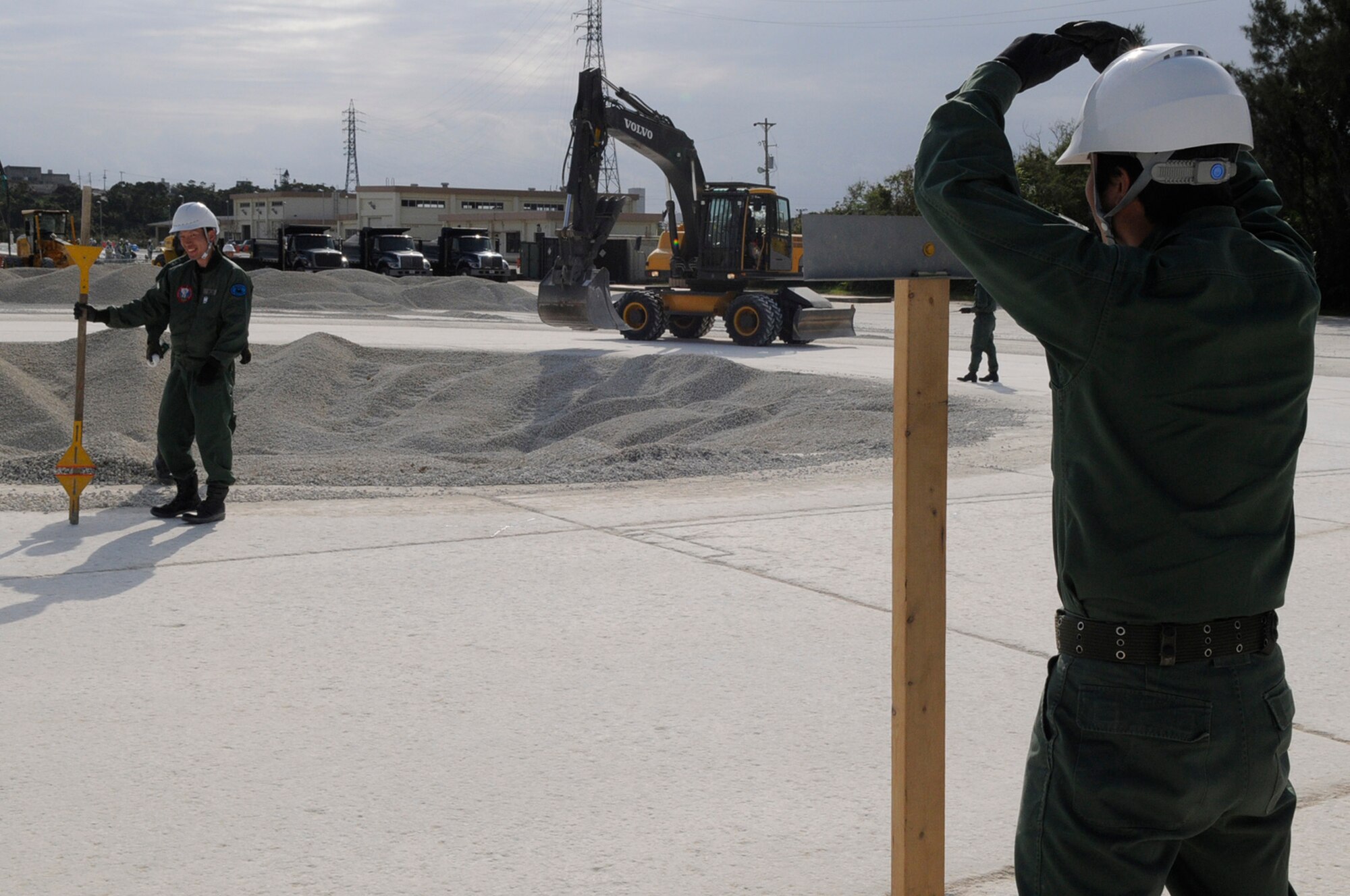 An engineer of the Koku Jieitai, or Japan Air Self-Defense Force, engineer gives the "OK" sign for his fellow engineers to mark a spot on the edge of a crater they are repairing at the U.S. Air Force Detachment 1, 554th RED HORSE Squadron training site on Kadena Air Base, Japan, March 13, 2012. The Japanese spent March 8-12 participating in the classroom portion of the training before moving outside to practice what they learned. (U.S. Air Force photo by Airman 1st Class Tara A. Williamson/Released)