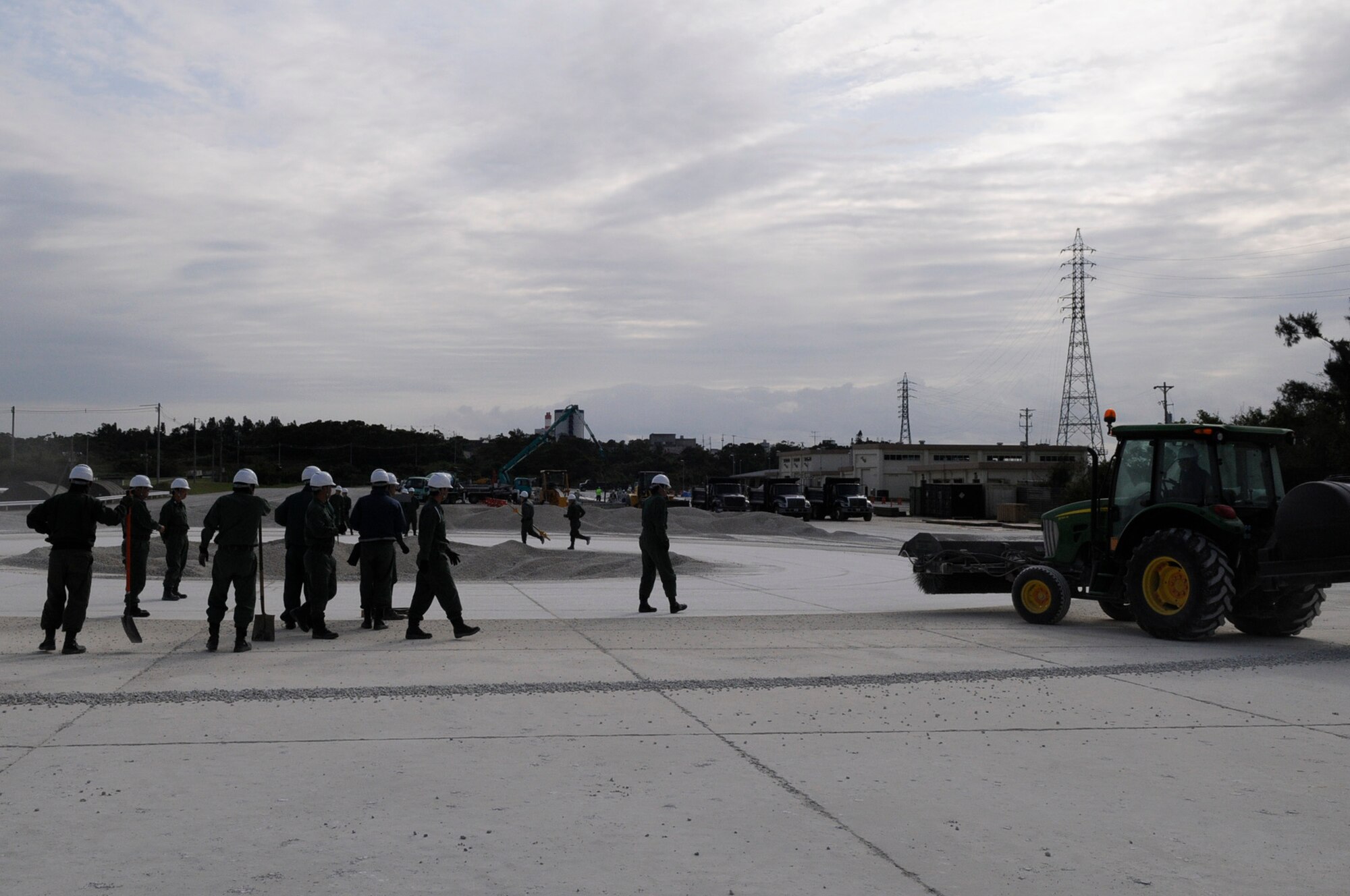 Members of the Koku Jieitai, or Japan Air Self-Defense Force, taking a runway crater repair class begin their day by clearing away debris from a crater they will repair at the U.S. Air Force Detachment 1, 554th RED HORSE Squadron training site on Kadena Air Base, Japan, March 13, 2012. Training with the Japanese builds on the strong bilateral friendship between the U.S. military and Japan's defense forces. (U.S. Air Force photo by Airman 1st Class Tara A. Williamson/Released)
