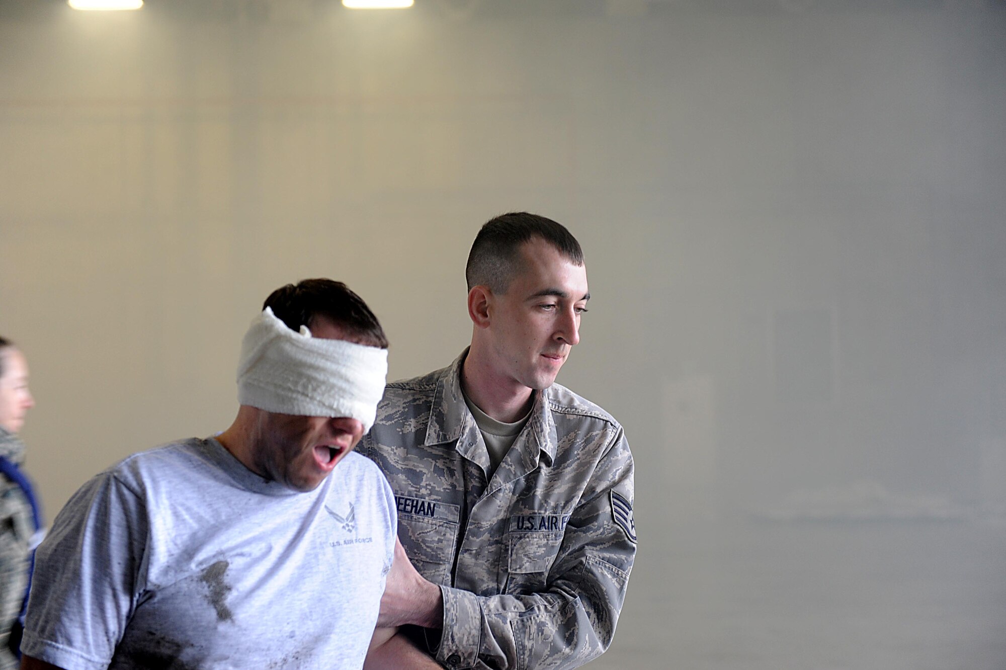 U.S. Air Force Staff Sgt. Daniel Meehan, 18th Component Maintenance Squadron technician, helps a victim escape from a smoke filled hangar during a training scenario on Kadena Air Base, March 14, 2012. Kadena is participating in a local operational readiness exercise to prepare Airmen for future contingencies. (U.S. Air Force photo by Airman 1st Class Brooke P. Beers/Released)