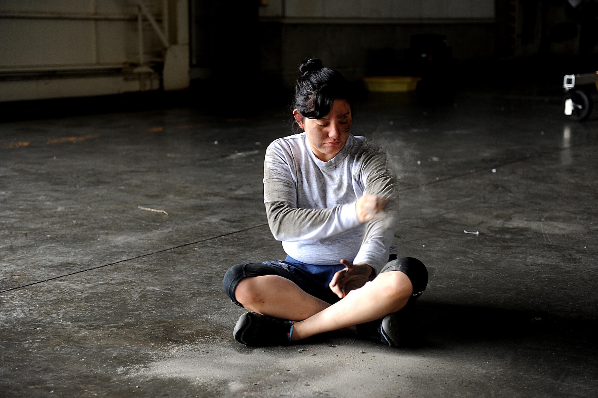 U.S. Air Force Staff Sgt. Kerly Ordonez, 82nd Reconnaissance Squadron, brushes herself with dirt to simulate being a victim of a bomb attack on Kadena Air Base, March 14, 2012. Kadena is participating in a local operational readiness exercise to prepare Airmen for future contingencies. (U.S. Air Force photo by Airman 1st Class Brooke P. Beers/Released)