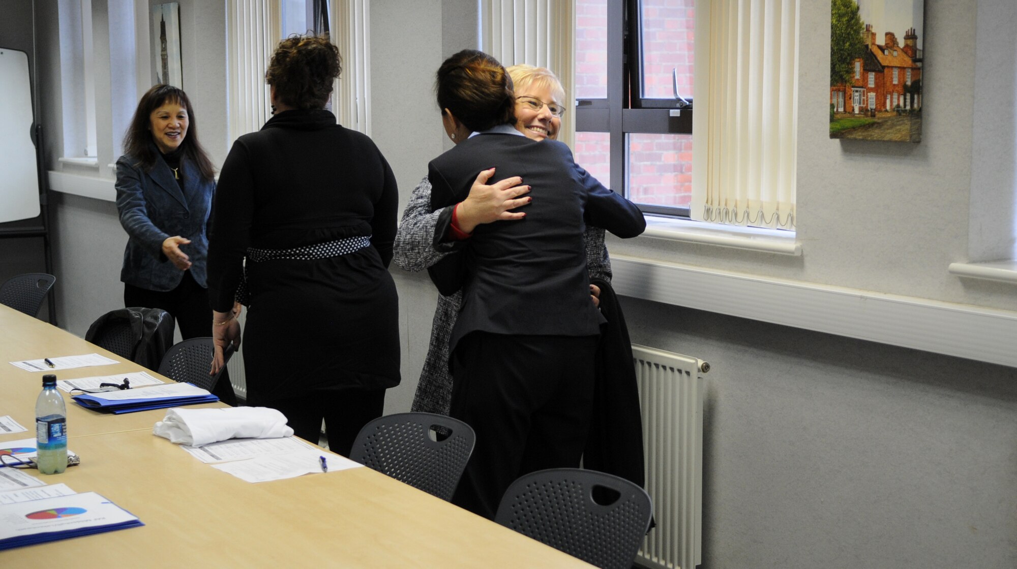RAF MILDENHALL, England – Paula Roy, wife of Chief Master Sgt. of the Air Force James Roy, greets Airman and Family Readiness Center personnel with hugs during a visit here March 13, 2012. Roy accompanied her husband during site visits to RAF Mildenhall and RAF Lakenheath, touring various support facilities and discussing their effectiveness with program directors. (U.S. Air Force photo/Staff Sgt. Austin M. May)