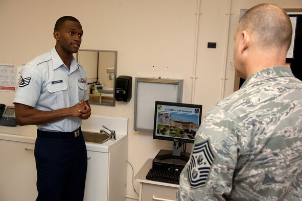 RAF CROUGHTON, United Kingdom - Staff Sgt. Isaac Adimora, 423rd Medical Squadron, provides an overview of the quality of life impacts generated by the RAF Upwood Clinic to Chief Master Sgt. of the Air Force James Roy during his visit to the 501st Combat Support Wing March 12. Airmen from the wing’s three air base groups briefed Roy on how their limited scope medical treatment facilities contribute to the wing’s mission. (U.S. Air Force photo by Tech. Sgt. John Barton)
