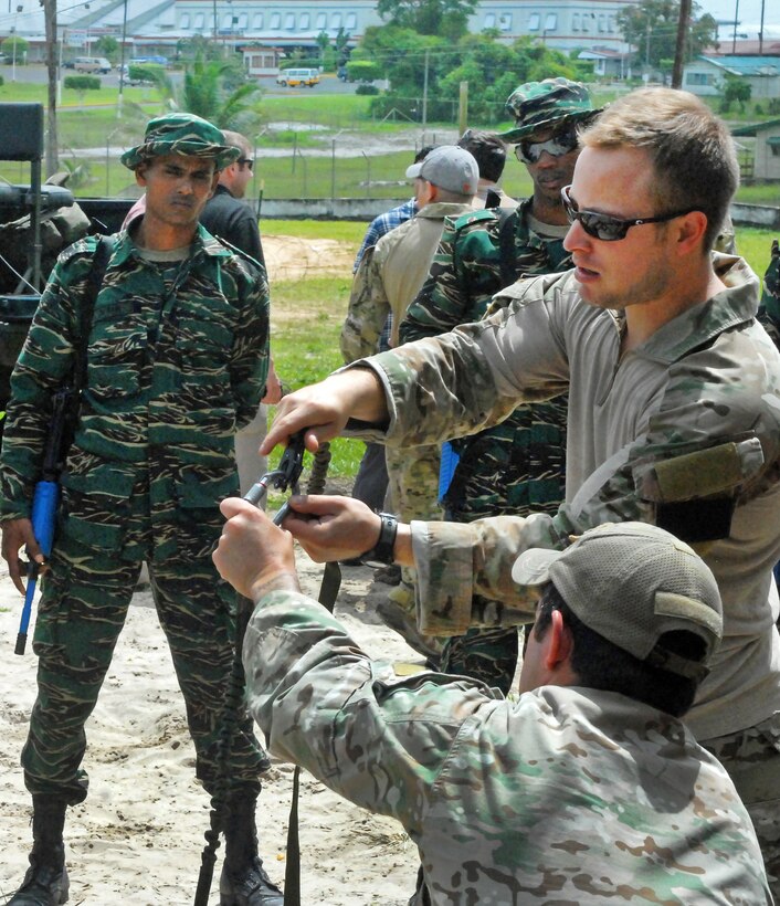 U.S. special operations forces instruct a Guyanese soldier on the proper way to use personal rigging equipment during a training event near Camp Stephenson, Guyana, March 3, 2012.