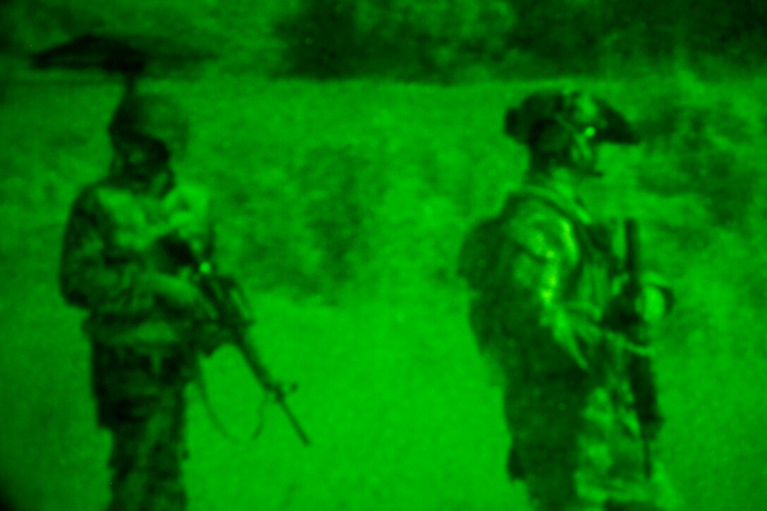 A U.S. special operations forces soldier  is accompanied by a Guyanese soldier on a patrol during a night time training event in Maukuria, Guyana, March 8, 2012.