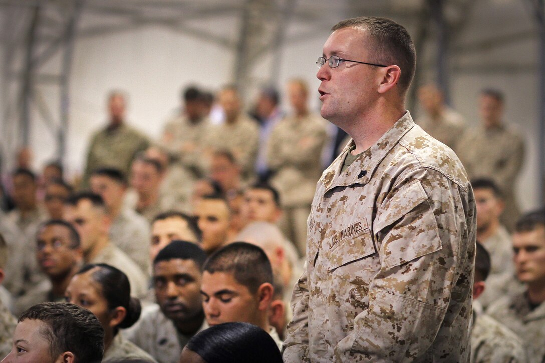 U.S. Marine Corps Sgt. Timothy Guy Jr. asks U.S. Defense Secretary Leon E. Panetta a question about the future of the U.S. military presence overseas during a town hall meeting on Camp Leatherneck, Afghanistan, March 14, 2012. Guy is assigned to the 1st Marine Logistics Group, Forward.