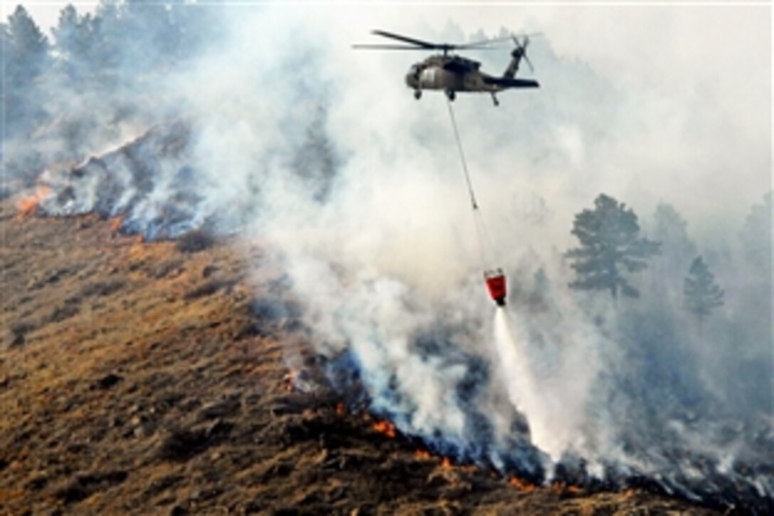 A South Dakota Army National Guard UH-60 Black Hawk helicopter drops 600 gallons of water on a fire in Rapid City, South Dakota, March 9, 2012. The helicopter crew is assigned to the Army National Guard Aviation Support Facility.