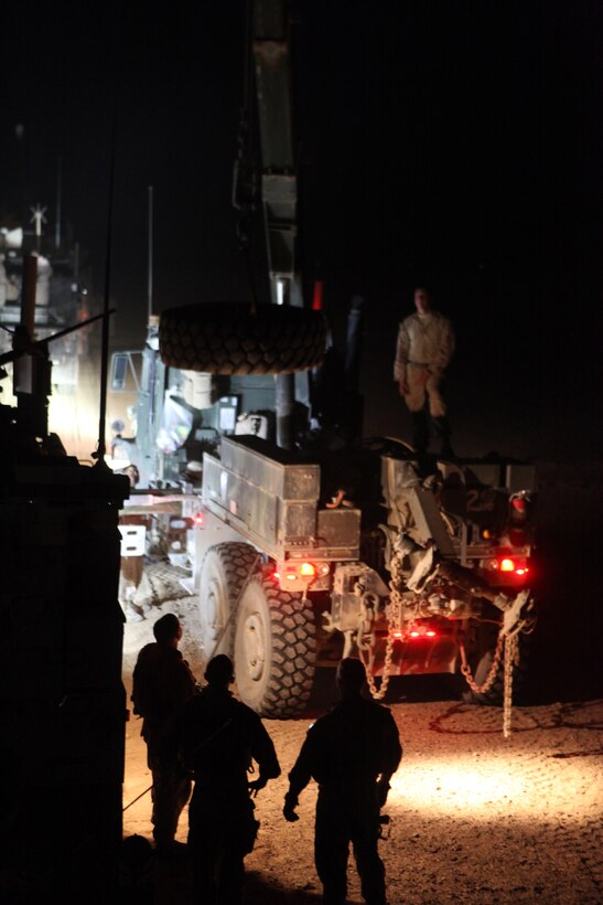 Marines with 2nd Platoon, General Support Motor Transport Company, Marine Air-Ground Task Force Support Battalion 11.2, 1st Marine Logistics Group (Forward) prepare to change a tire after stopping for the evening, March 14. The Marines worked to fix the disabled vehicle prior to the next morning’s convoy.