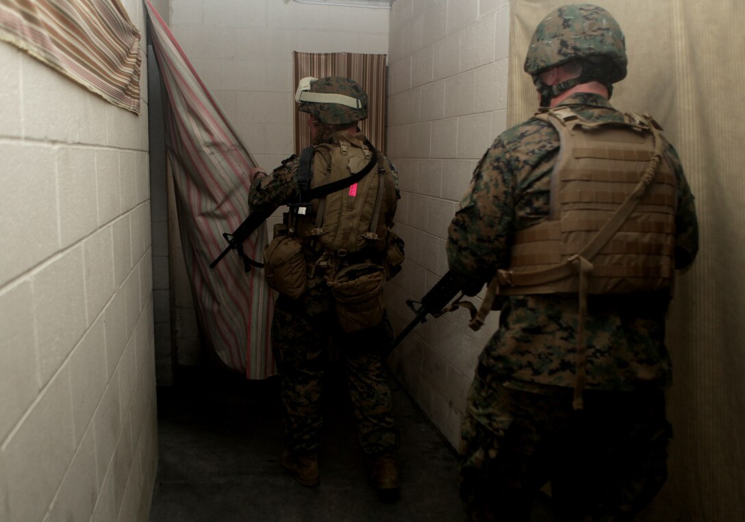 Marines with Production and Analysis Support Company, 2nd Intelligence Battalion, II Marine Expeditionary Force, search a building during the Counter Improvised Explosive Device Lane, March 8. The training provided intelligence analysts with an up close and personnel look at life on the ground while deployed, with the intent of giving the participants a better sense of perspective and understanding while interpreting raw intelligence information during their upcoming deployment.