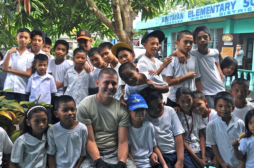 Airman 1st Class Taylor Vondrasek, 36th Civil Engineer Squadron structural apprentice, Andersen Air Force Base, Guam, takes a moment to connect with the children from Binitayan Elementary School, Legazpi City, Philippines, on March 5, 2012. Vondrasek and fellow engineers from the U.S. and Philippine military forces rebuilt three class rooms at the school during the six-day mission. Another group of engineers rebuilt a huge classroom at Bigaa Elementary School, Bigaa, Philippines.  The students spent time at recess observing the engineers during Operation Pacific Angel-Philippines, a joint and humanitarian mission, which included engineering support to the region as well as medical, dental, optometry and subject-matter expert exchanges. (U.S. Air Force photo/Master Sgt. Allison Day)
 
