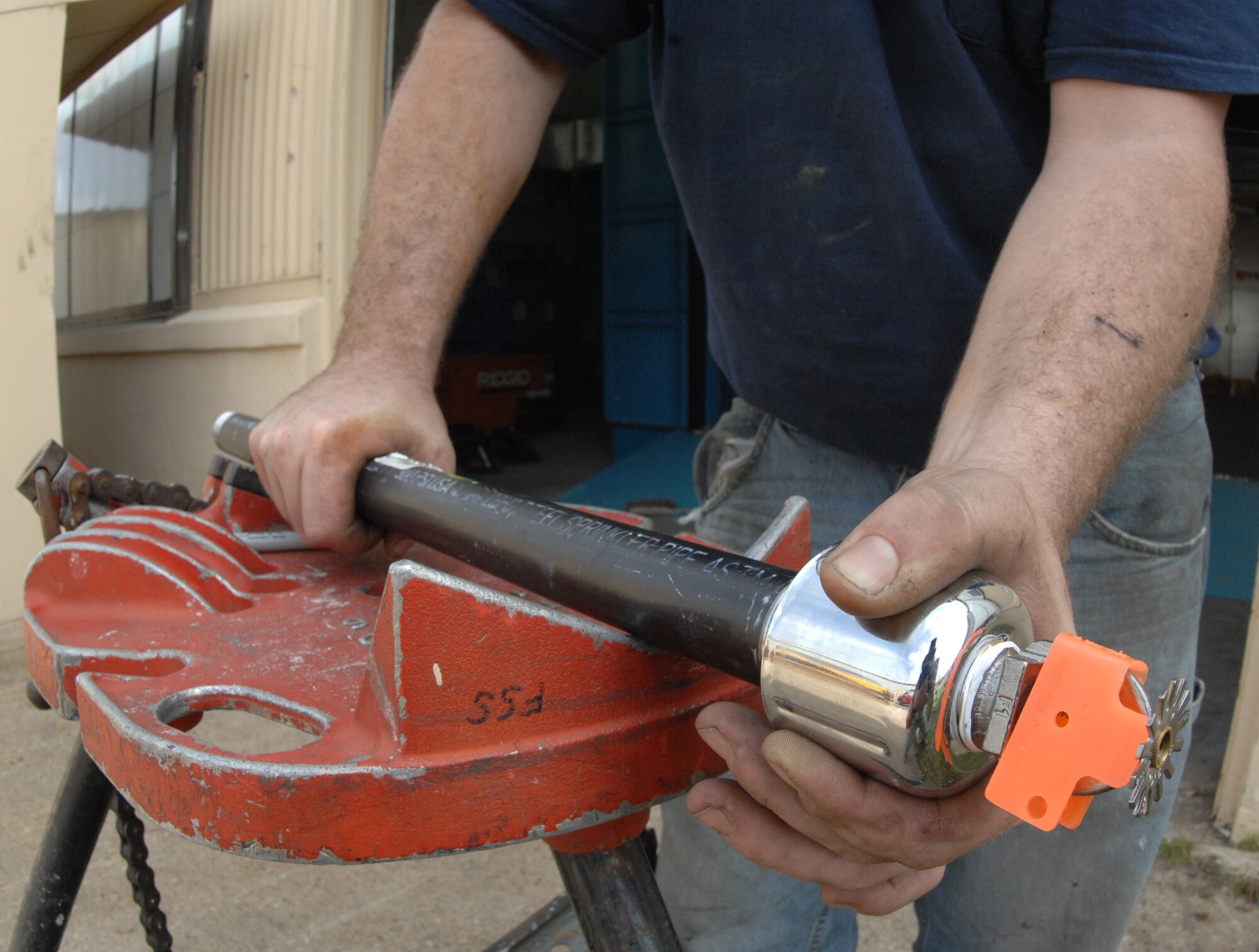 David Hudson, Fire and Sprinkler Services installer, mounts a sprinkler head to a branch line at the 2nd Maintenance Squadron structural maintenance coating shop on Barksdale Air Force Base, La., March 14. The branch line and sprinkler head are the final pieces that need to be connected to complete the installation inside and on top of the paint booth. (U.S. Air Force photo/Airman 1st Class Joseph A. Pagán Jr.)(RELEASED)