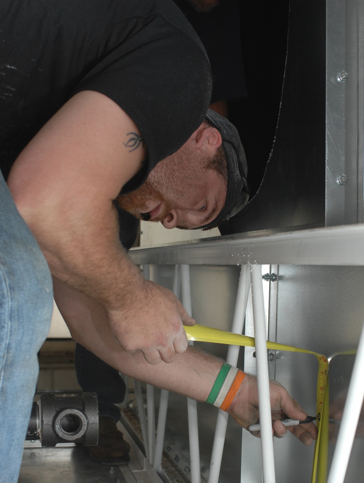 David Hudson, Fire and Sprinkler Services installer, marks a center point for a hole on top of a paint booth at the 2nd Maintenance Squadron structural maintenance coating shop on Barksdale Air Force Base, La., March 13. Hudson cut a hole to place a branch line through the wall during the installation of a new sprinkler system. (U.S. Air Force photo/Airman 1st Class Joseph A. Pagán Jr.)(RELEASED)