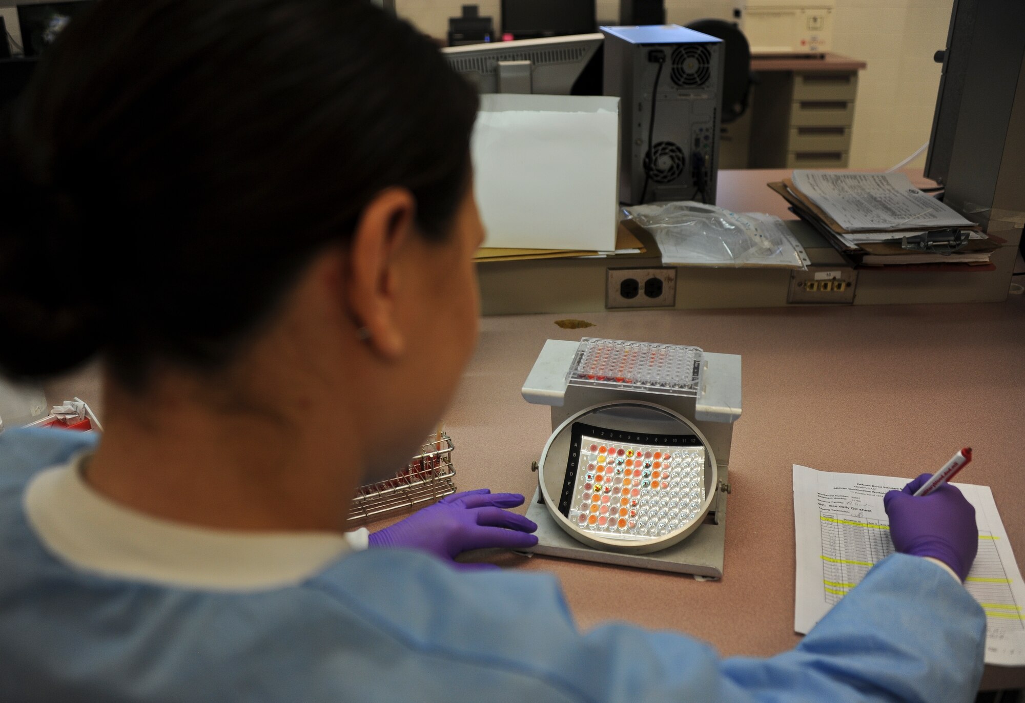 Tech. Sgt. Ursula Widener, Armed Services Whole Blood Processing Laboratory East technician, drops blood into a tray to test the blood type using different chemical solutions. The ASWBPL-East service members send more than 1,200 units of blood to 32 DOD and coalition medical treatment facilities throughout U.S. Central Command. (U.S. Air Force photo by Airman 1st Class Dennis Sloan/Released) 