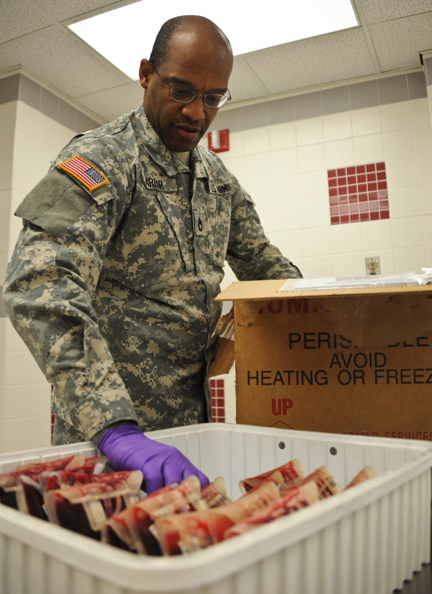 Sgt. First Class Lavon Harbor, Armed Services Whole Blood Processing Laboratory East NCO in-charge, packages blood into a specialized plastic foam box with ice to be taken to the flightline for shipment to the Area of Operations. The unit processes, stores, tests and packages blood for shipment. The blood is vital not only to warfighters, but also DOD medical beneficiaries throughout U.S. Africa Command and U.S. European Command. (U.S. Air Force photo by Airman 1st Class Dennis Sloan/Released)