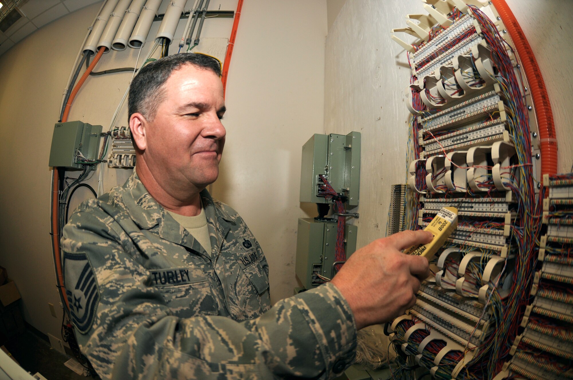 Master Sgt. Dan Turley, 419th Communications, uses his tools to make sure phone wires are transmitting sound and working properly. The phones connected to these wires are used to communicate weather conditions to aircraft on and off the flight line at Joint Base Pearl Harbor-Hickam. Ten reservists from comm are here on annual tour helping the active duty transfer computers to a new system. (U.S. Air Force photo/Senior Airman Crystal Charriere)