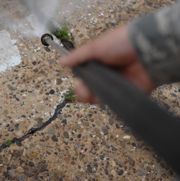 Airman 1st Class Anthony Ohl, 2nd Civil Engineer Squadron, power washes parking lines on Barksdale Air Force Base, La., March 15. The 340th Weapons squadron and 26th Operational Weather Squadron requested the parking spots to be removed as a security measure to keep employees and visitors from parking next to the building. (U.S. Air Force photo/Airman 1st Class Joseph A. Pagán Jr.)(RELEASED)