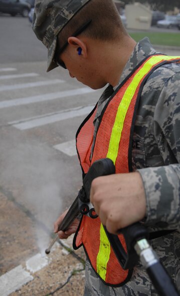 Airman 1st Class Anthony Ohl, 2nd Civil Engineer Squadron, removes parking lines on Barksdale Air Force Base, La., March 15. The 340th Weapons squadron and 26th Operational Weather Squadron requested the parking spots to be removed as a security measure to keep employees and visitors from parking next to the building. (U.S. Air Force photo/Airman 1st Class Joseph A. Pagán Jr.)(RELEASED)