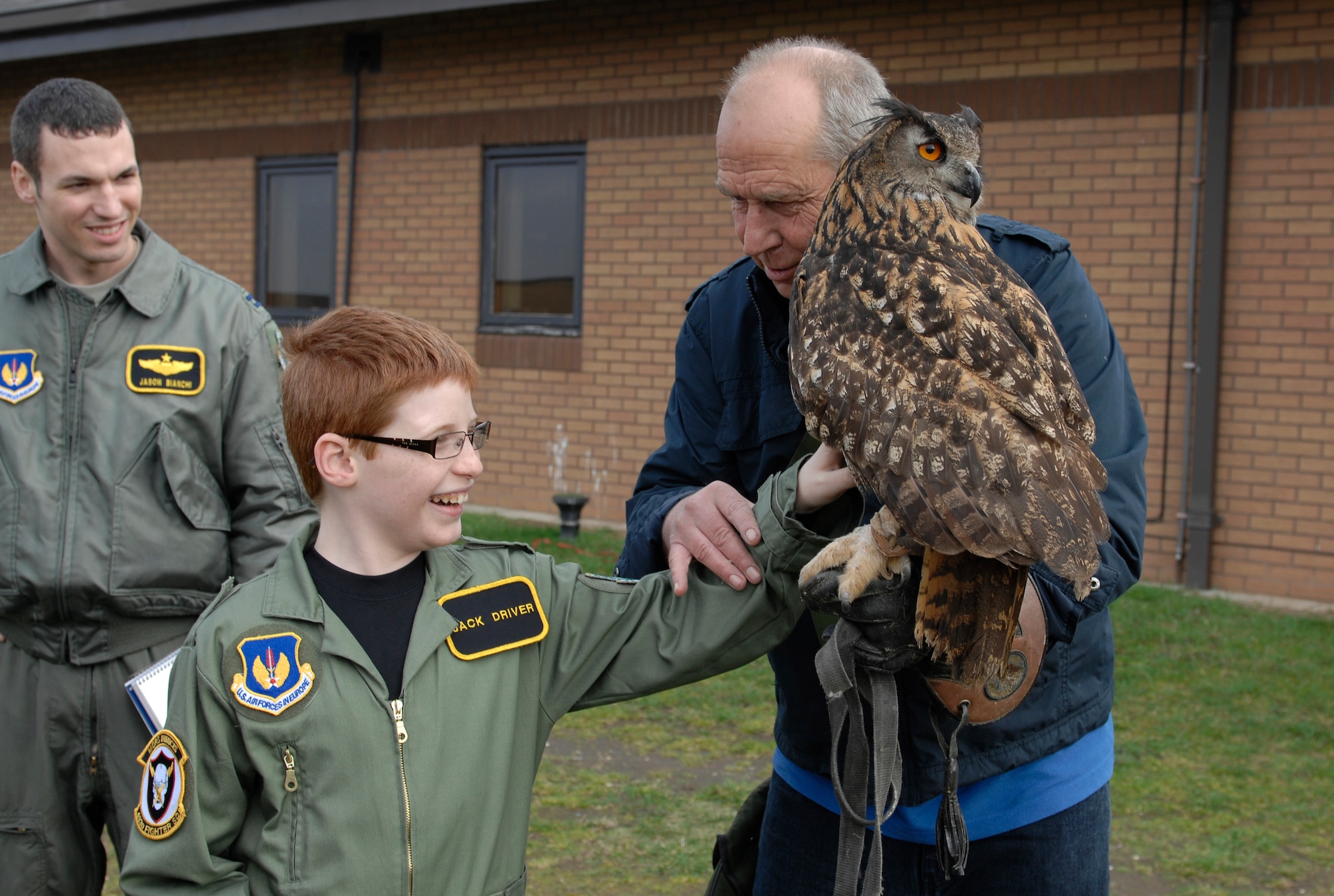 ROYAL AIR FORCE LAKENHEATH, England -- Jack Driver, 10, feels the feathers of Twinkle, an eagle owl, as Keith Mutton, Phoenix Bird Control handler, holds her during a "Birds of Prey" demonstration as part of the Pilot for a Day program March 14, 2012.  Jack was surprised by his parents with the trip to RAF Lakenheath where he received briefings, a flight suit, tours and various demonstrations. The Pilot for a Day program is a new program designed to assist children in the local community who are fighting life-threatening illnesses or conditions by providing a day of fun as a break from the routine doctor and hospital visits.  (U.S. Air Force photo by Tech. Sgt. Lee A. Osberry Jr.)