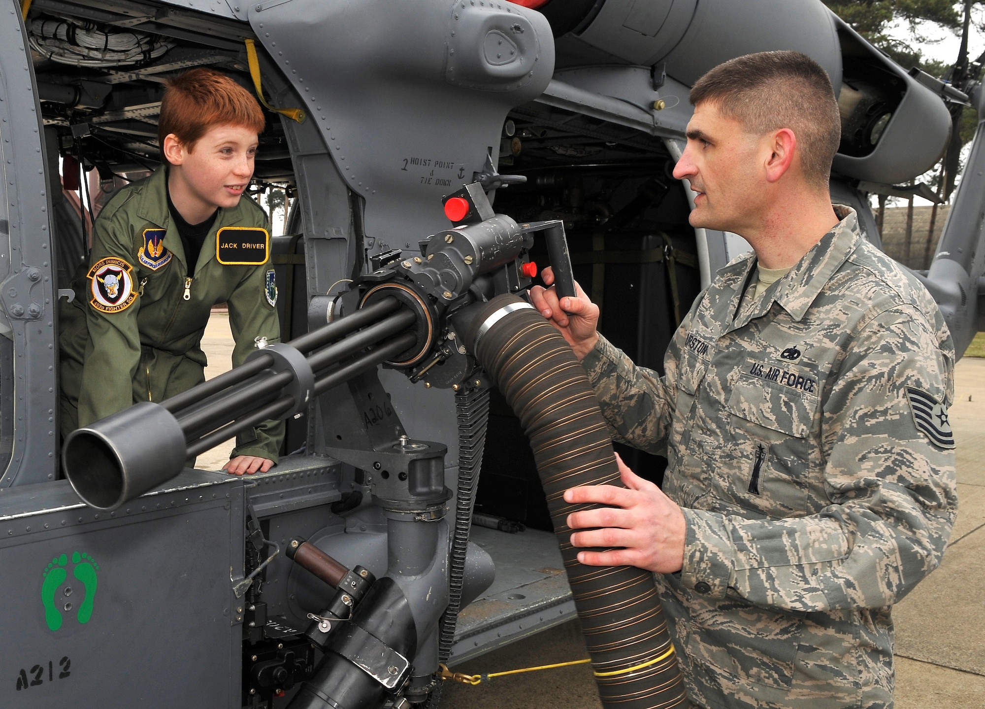 ROYAL AIR FORCE LAKENHEATH, England -- Jack Driver, 10, learns how to operate a GAU-2C mini-gun from Tech. Sgt. Dietrich Thurston, 748th Aircraft Maintenance Squadron weapons expeditor, inside an HH-60 Pave Hawk helicopter on the RAF Lakenheath flightline March 14, 2012.  Driver, who suffers from Aplastic Anemia, a rare auto immune disorder where bone marrow fails to make enough blood cells, was selected as a pilot for the day.  The Pilot for a Day program is new to RAF Lakenheath and provides children in the local community, who are fighting life-threatening illnesses or conditions, a day of fun as well as a break from the routine doctor and hospital visits. (U.S. Air Force photo by Staff Sgt. Connor Estes)