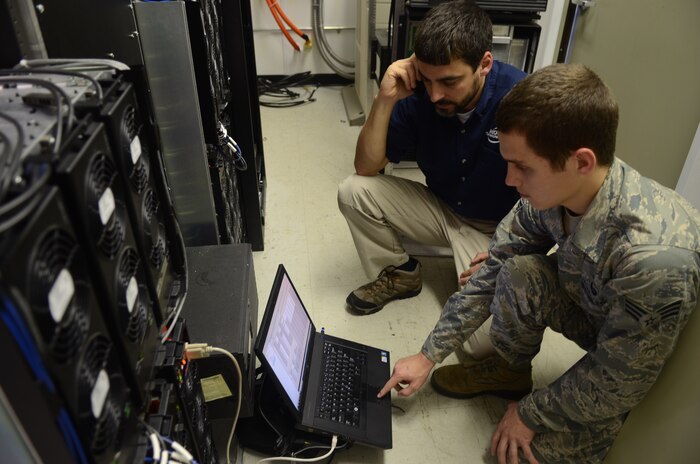 Senior Airman Adam Pollard and Andre Lafon continually work on repairing the portable land mobile radio trunk equipment March 14, after the damage caused by the lightning strike. Pollard is the 628th Communications Squadron RF transmissions systems technican and Lafon is a wireless systems engineer from Mobile communications of Charleston. (U.S. Air Force photo / Tech. Sgt. Chrissy Best )