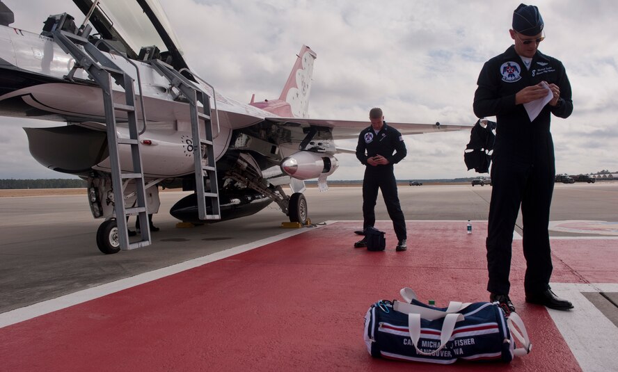 U.S. Air Force Capt. Michael Fisher, Thunderbird 8 advanced pilot and narrator, and Staff Sgt. Raymond LeBlanc, flying crew chief, gather gear after their arrival at Moody Air Force Base. Ga., Feb. 16, 2012. The team performed a flyover of the base for a better look at the layout of the base, which will prepare the team for the the the Legacy of Liberty 2012 airshow, Oct. 27 and 28. (U.S. Air Force photo by Airman 1st Class Nicholas Benroth/Released)