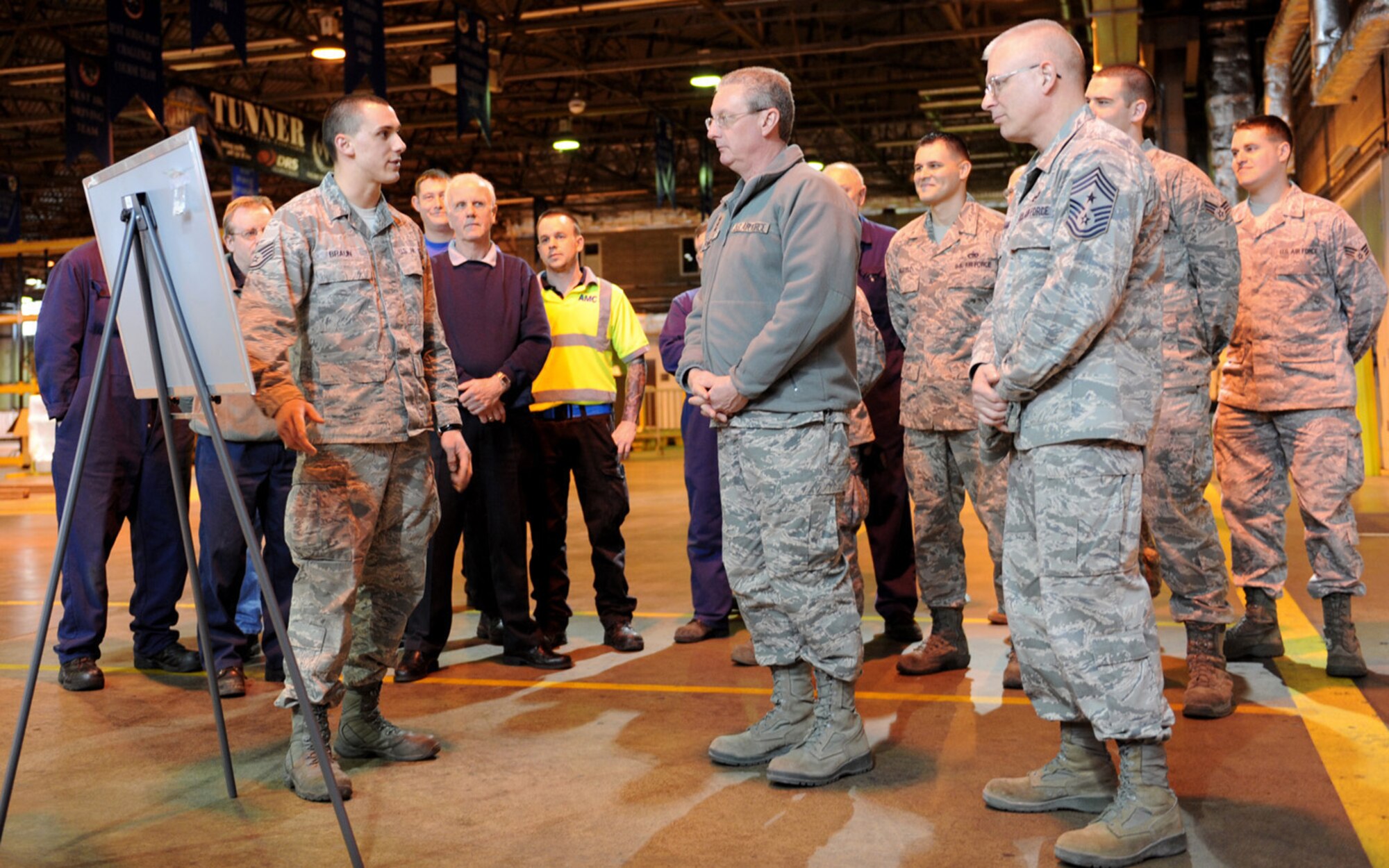 RAF Mildenhall -- Lt. Gen. Mark F. Ramsay, center, 18th Air Force commander, listens as Staff Sgt. Joshua Braun, 727th Air Mobility Squadron freight services supervisor, briefs at the freight terminal here March 13, 2012. Braun briefed the general on the amount of cargo the squadron routinely moves and the diversity of units that they support. Ramsay was at the base meeting Airmen and Ministry of Defence personnel. (U.S. Air Force photo/Tech. Sgt. Neal X. Joiner)