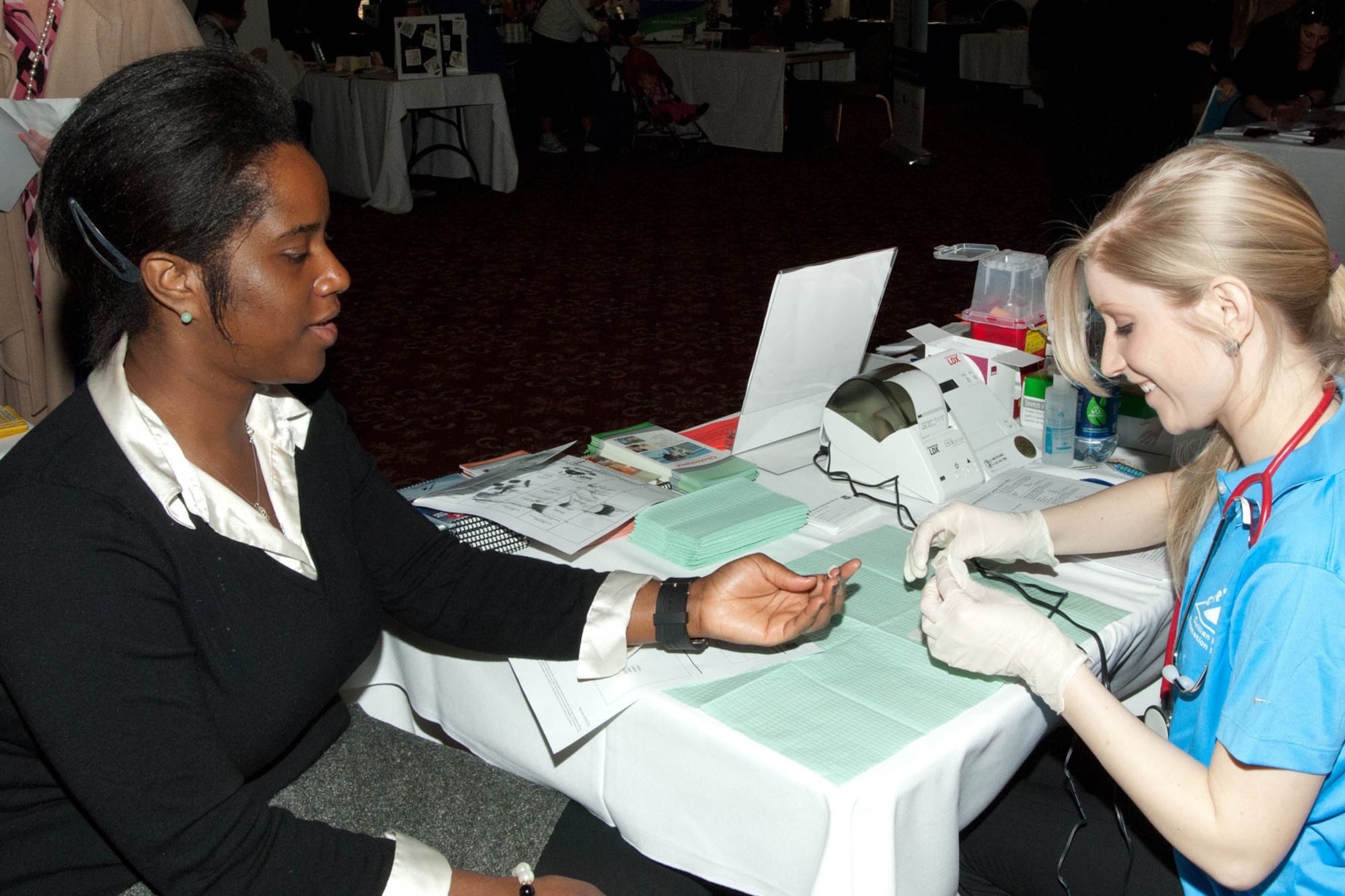 HANSCOM AIR FORCE BASE, Mass. - Orlagh Pawlyk (right), Civilian Health Promotions Services health promoter, does a health screening with Coletha Cox, 66th Force Support Squadron, during the Health Expo at the Minuteman Commons March 8. In addition to CHPS, other base agencies and community organizations attended to offer health and wellness tips, demonstrations, information and giveaways. (U.S. Air Force photo by Linda LaBonte Britt) 