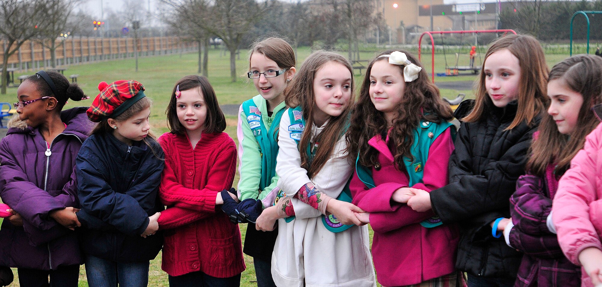 ROYAL AIR FORCE LAKENHEATH, England - Girls perform a friendship circle during the Girl Scouts' 100th Birthday event at Defender's Park March 12, 2012. The event, planned by the members of Anglia Brownie Troop 43, included a group sing-along, friendship circle, cupcakes and fun. (U.S. Air Force photo by Senior Airman Tiffany M. Deuel)