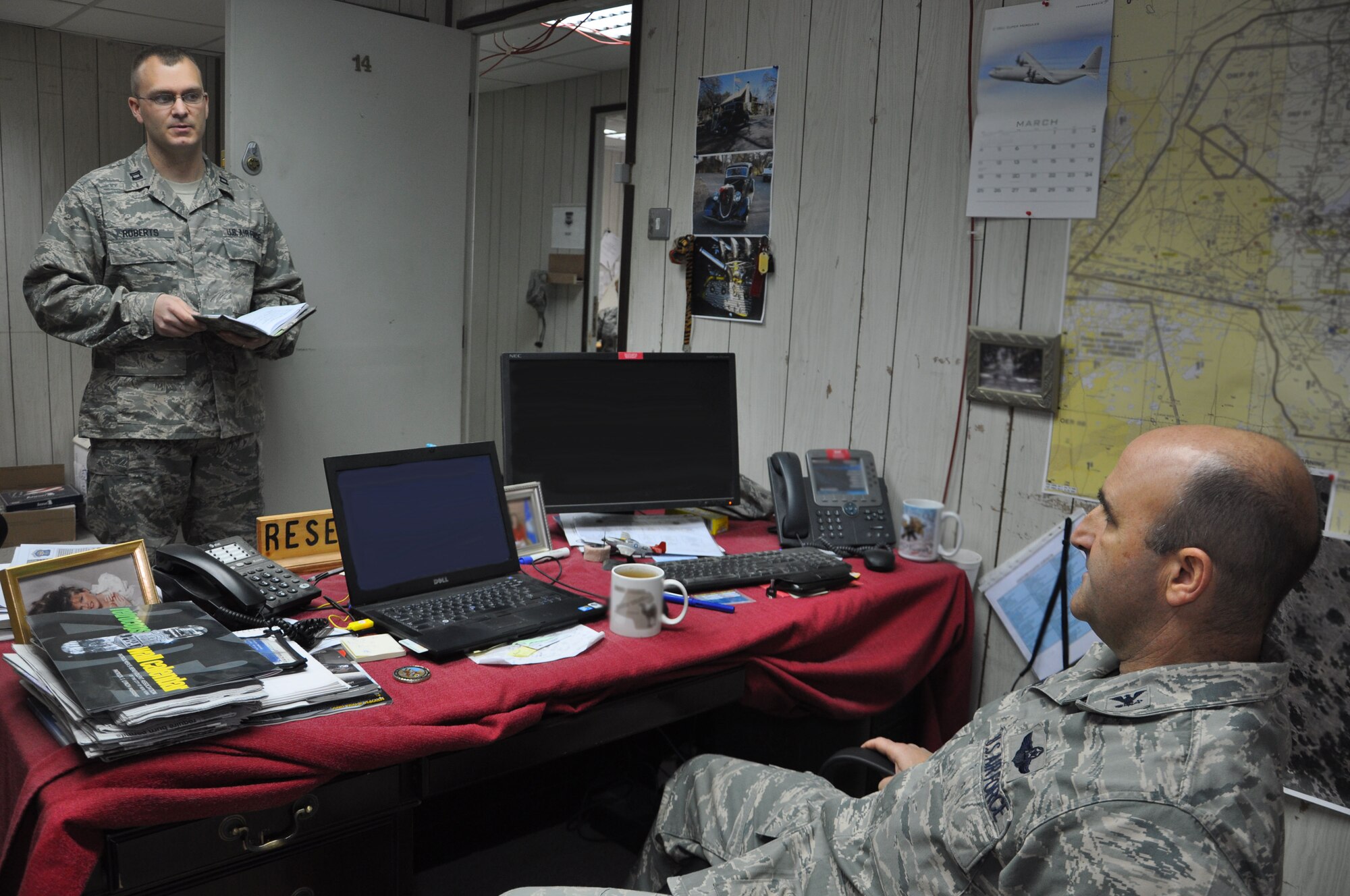 SOUTHWEST ASIA -- Capt. James Roberts, 332nd Expeditionary Operations Group executive officer, briefs Col. Rodney Petithomme, 332nd EOG commander, about his upcoming appointments March 15, 2012 at an undisclosed location in Southwest Asia. Roberts was named the AETC 2011 Weather Company Grade Officer of the year for his accomplishment at his home station. He is deployed from Altus Air Force Base, Okla., and is a native of Pearl River, La. (U.S. Air Force photo illustration by Senior Airman Melanie Holochwost)