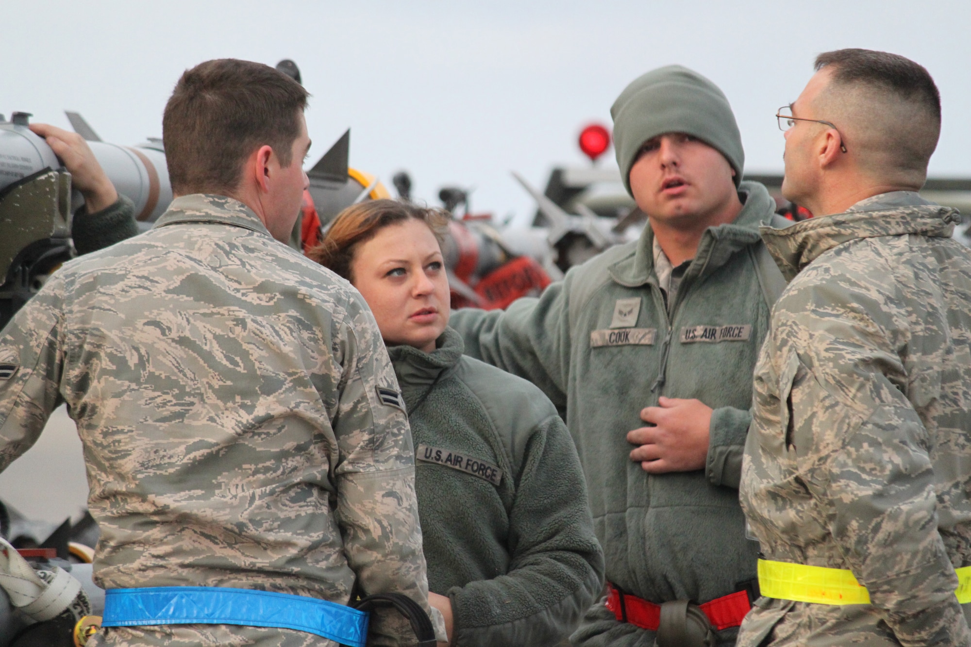 U.S. Air Force Airman 1st Class Justin Harding and Staff Sgt. Nicole Drapeau, both belonging to the 44th Aircraft Maintenance Unit, and U.S. Air Force Airman 1st Class Chris Cook, 67th AMU, discuss weapons loading operations with U.S. Air Force Chief Master Sgt. Ed Runkle, an exercise evaluator during local operational readiness exercise Beverly High 12-3 on Kadena Air Base, Japan, March 13, 2012. Procedures are evaluated during LOREs to ensure tasks are done right and no one will be accidentally injured. (U.S. Air Force photo by Maj. John M. Jacobus/Released)