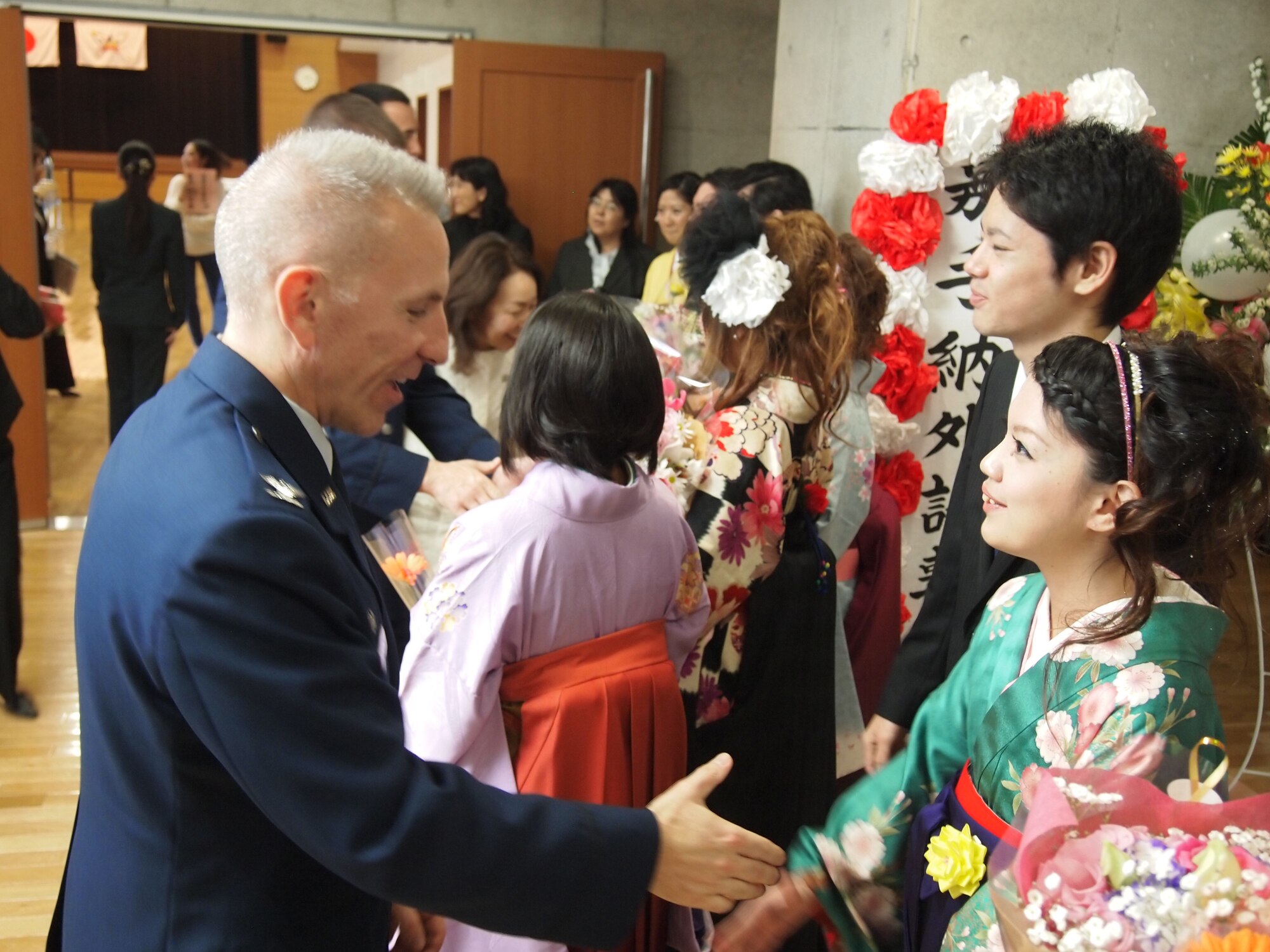 U.S. Air Force Col. Roftiel Constantine, 18th Mission Support Group Commander, congratulates students from students who graduated from Kadena Language Institute, March 9, 2012, at the Kadena Town Central Community Center, Okinawa, Japan.  The 18th Wing annually accepts KLI student interns and provides hands-on work experiences in an English-speaking environment.  The class of 2012 worked at various units on Kadena Air Base.  (Courtesy Photo of Kadena Language Institute)