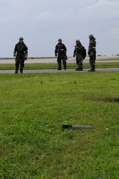 Airmen from the 33rd Rescue Squadron identify an unexploded ordnance and report it to the unit control center while performing a post-attack reconnaissance sweep of the building perimeter during local operational readiness exercise Beverly High 12-3 on Kadena Air Base, Japan, March 14, 2012. A PAR sweep is performed after an "enemy attack" to check for UXOs and any victims. (U.S. Air Force photo by Airman 1st Class Tara A. Williamson/Released)