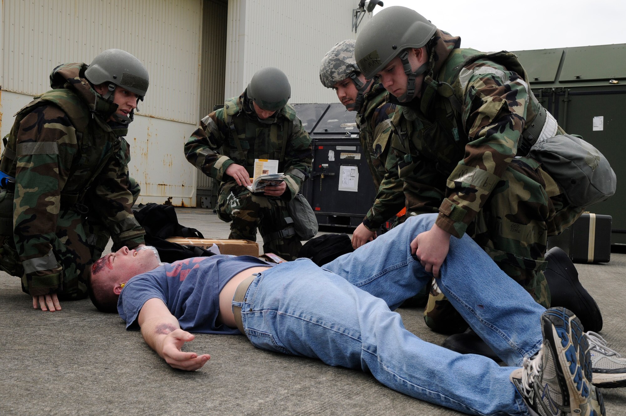 Airmen from the 33rd Rescue Squadron elevate the legs of a simulated victim after an "enemy attack" during local operational readiness exercise Beverly High 12-3 on Kadena Air Base, Japan, March 14, 2012. During LORE scenarios, Airmen are encouraged to use the Airman's Manual to find the proper procedures to help them through any situation. (U.S. Air Force photo by Airman 1st Class Tara A. Williamson/Released)