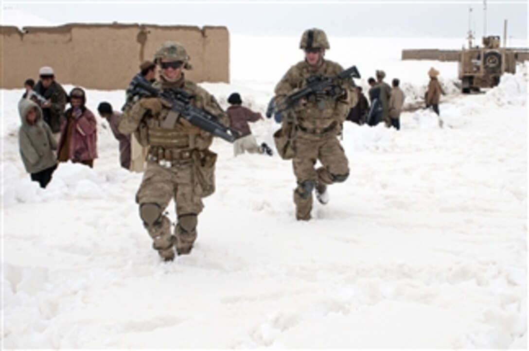U.S. Army Sgt. Nick Lightwine and Sgt. Rob Logue, with 5th Battalion 20th Infantry Regiment, 14th Cavalry Regiment, make their way to their Mine Resistant Ambush Protected truck following a successful snow clearance patrol through the village of Menden Kheyl, in Helmand province, Afghanistan, on Feb. 19, 2012.  