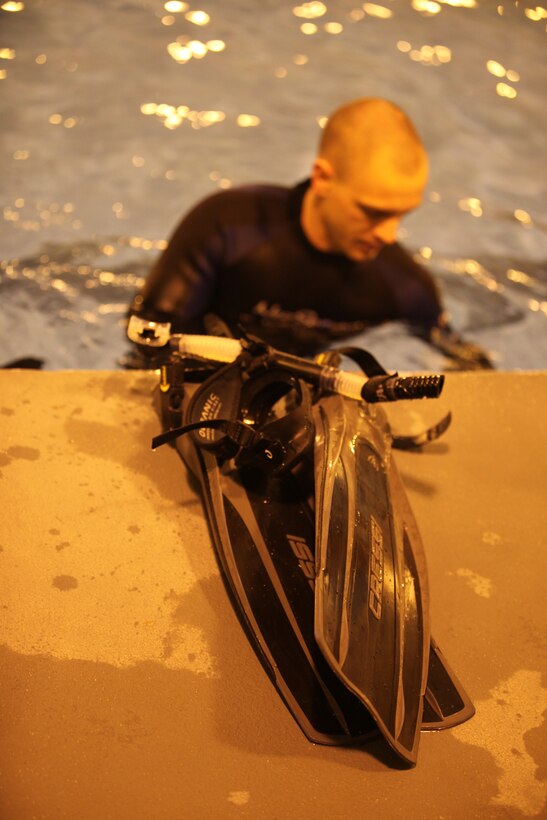 A student removes his scuba gear during the Open Water certification class, one of many scuba classes offered aboard Marine Corps Base Camp Lejeune March 16. The class has 4 sessions in which students learn basic skills needed to scuba dive.