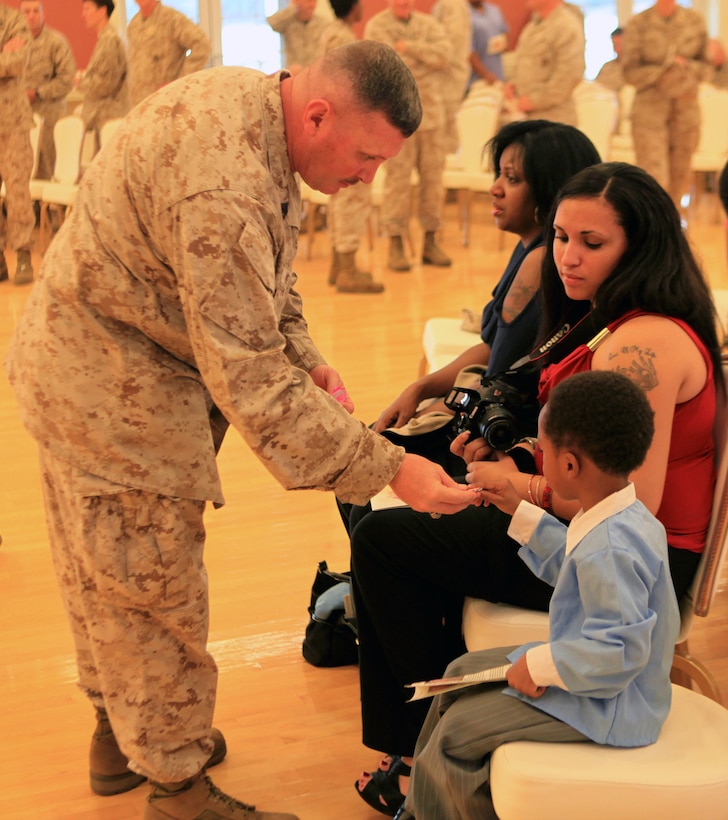 Sgt. Maj. Herbert Wayne Wrench, the sergeant major of 2nd Marine Logistics Group, speaks to his three-year-old grandson, Isaiah, during his retirement ceremony aboard Camp Lejeune, N.C., March 16, 2012.  Wrench said Isaiah is who will keep him young and energetic for “the next 120 years.”  (U.S. Marine Corps photo by Cpl. Katherine M. Solano)