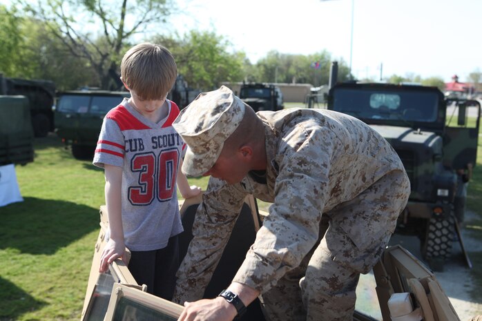 Cpl. Benjamin C. Christopher, a motor vehicle operator with Combat Logistics Battalion 8, 2nd Marine Logistics Group, plays in a tactical vehicle’s turret with a child during a static display at Patriots Point Naval and Maritime Museum, Charleston Harbor, S.C., March 16, 2012. The troops had a chance to talk to visitors about some of the vehicles they drive, which included Logistics Vehicle System Replacements, Medium Tactical Vehicle Replacements, Mine Resistance Ambush Protected All-Terrain Vehicles and High Mobility Multipurpose Wheeled Vehicles. (Photo by Cpl. Bruno J. Bego)