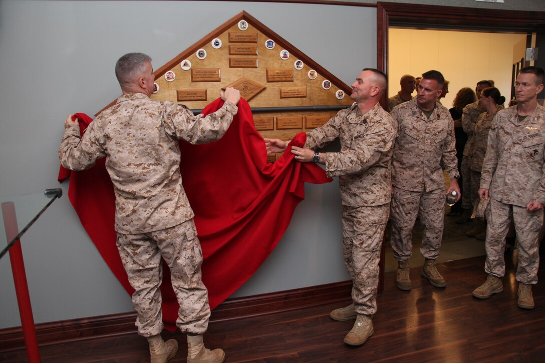 Maj. Gen. Glenn M. Walters and Sgt. Maj. Henry A. Prutch unveil a plaque dedicated to the successes of the 2nd Marine Aircraft Wing (Forward) during its yearlong combat deployment. 2nd MAW (Fwd) deactivated March 16 during a ceremony aboard MCAS Cherry Point, N.C.