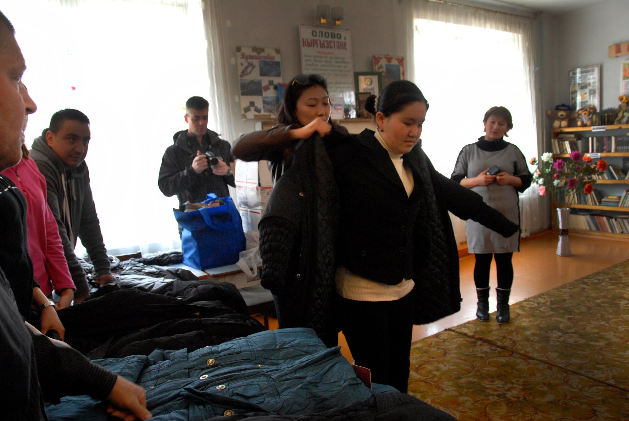 Mukasheva Aisuluu, 376th Expeditionary Force Support Squadron interpreter, helps Askar Kyzy Asida, an 11th grader at Jany Pahkta School in Bishkek, Kyrgyzstan, try on a jacket March 15, 2012. Although the 376th EFSS has already distributed jackets to the school, they wanted to ensure every child that needed received a jacket received one. (U.S. Air Force photo/Senior Airman Lynsie Nichols)