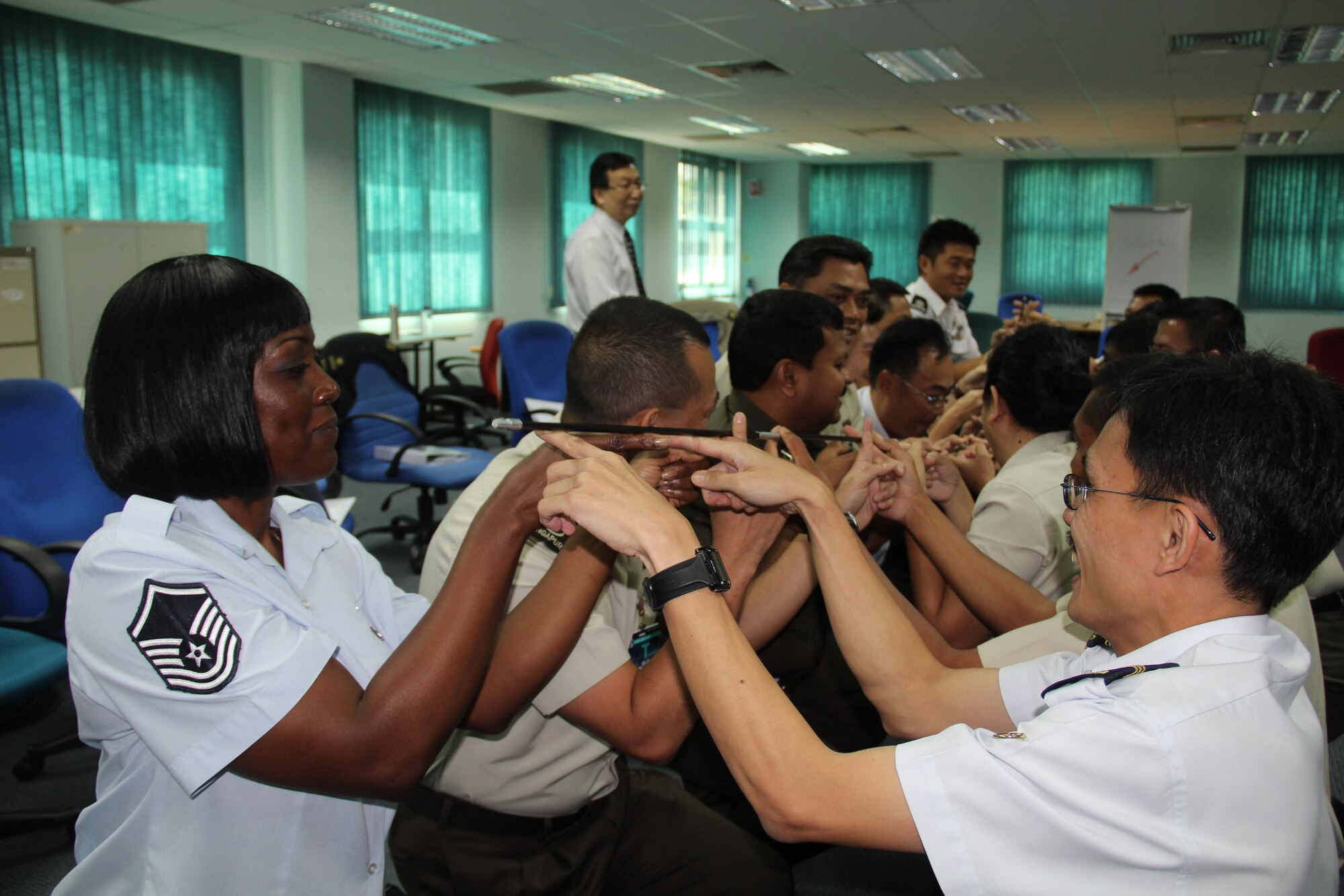 Master Sgt. Kelly Randolph, an aero medical evacuations strategic resources manager from Pacific Air Forces, attempts to hold a flimsy stick with her fingers along with her multinational partners during the Joint Advanced Leadership Course at Pasir Laba Camp, Republic of Singapore, Feb. 8, 2012. The three-week course which included Singapore Armed Forces, New Zealand Army, and U.S. Navy, encompassed subject matter similar to U. S. Air Force Professional Military Education. (Released/Courtesy photo)