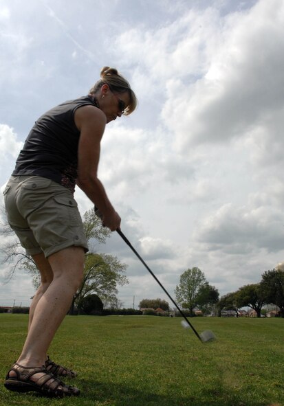 Kye Quesinberry, wife of Lt. Col. Milo Quesinberry, 2nd Mission Support Group, hits a golf ball at the Fox Run golf course on Barksdale Air Force Base, La. March 16. Kye Quesinberry played to help the Barksdale Officer's Spouses Club raise money for base organizations, scholarships and the off-base community. (U.S. Air Force photo/Airman 1st Class Joseph A. Pagán Jr.)(RELEASED) 