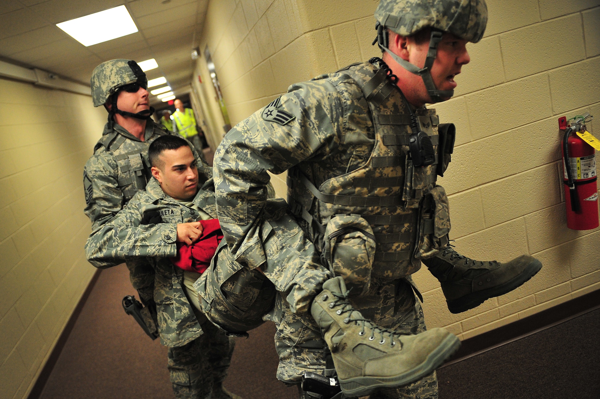 U.S. Air Force Master Sgt. Robert Wilson and Senior Airman Joshua Titus, 27th Special Operations Security Forces Squadron, carry a simluated wounded Airman to safety during an active shooter training scenario at Cannon Air Force Base, N.M., March 1, 2012. Training scenarios provide a safe and controlled environment to practice different tactics, techniques and procedures. (U.S. Air Force photo by Tech. Sgt. Josef Cole)