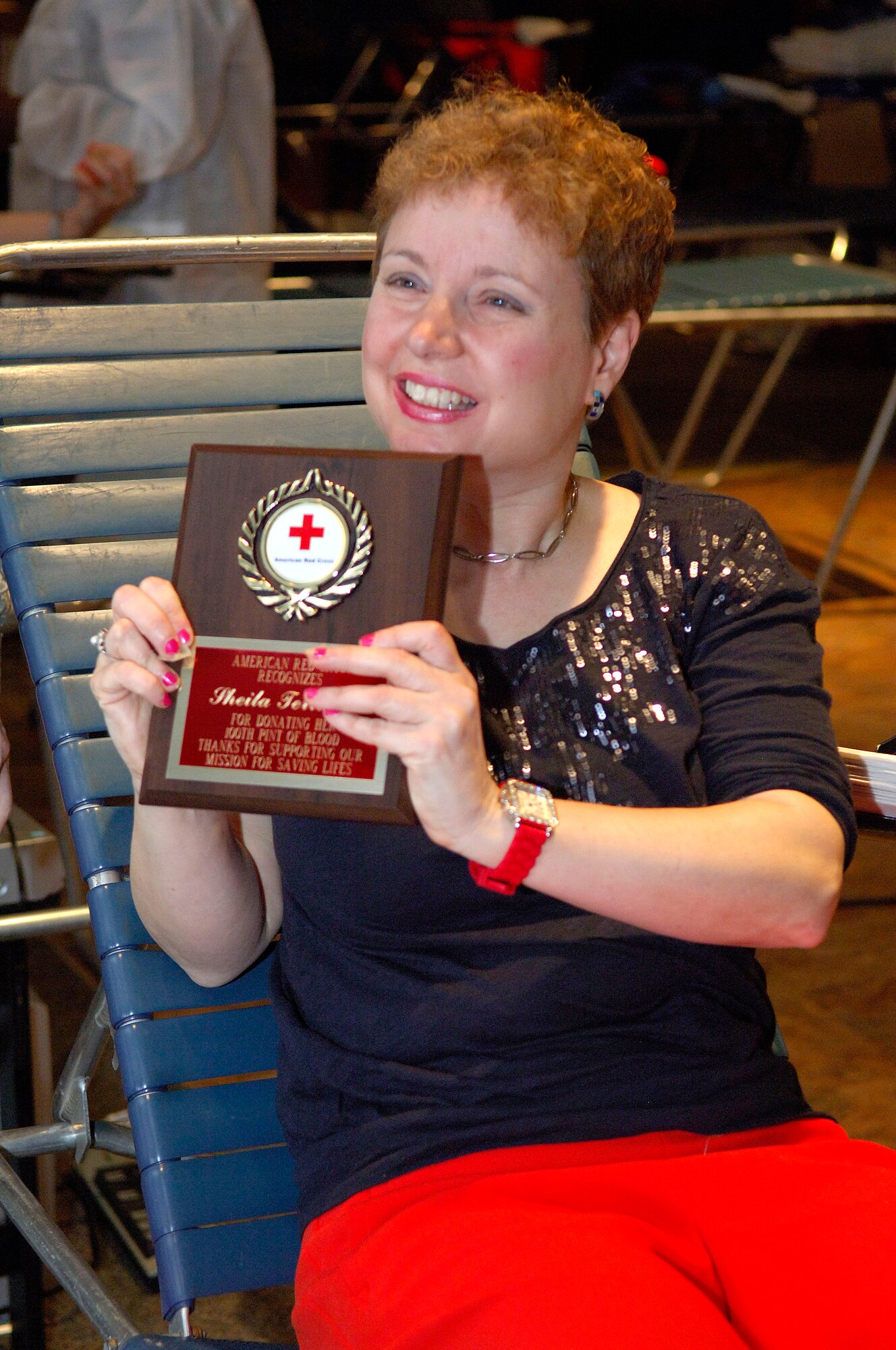 Sheila Terrando, Air Force Network Integration Center mail clerk, smiles as she holds her award she earned by giving her 100th pint of blood March 13, 2012 at Scott Air Force Base, Ill. Terrando has earned several awards in her 32 years of donating blood. (U.S. Air Force photo/Airman 1st Class Jake Eckhardt)
