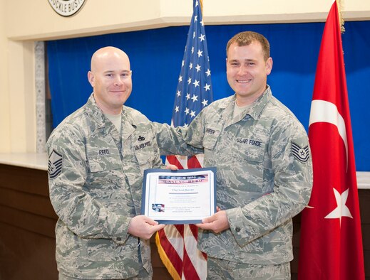 Tech. Sgt. Scott Barrier, 728th Air Mobility Squadron, is presented the Unsung Hero Award by Master Sgt. Alan Reed, a member of Incirlik Top 3, March 15, 2012, at Incirlik Air Base, Turkey. The Top 3 presents the Unsung Hero Award monthly to an Airman demonstrating superior job performance and exceptional leadership. (U.S. Air Force photo by Senior Airman Clayton Lenhardt/Released)