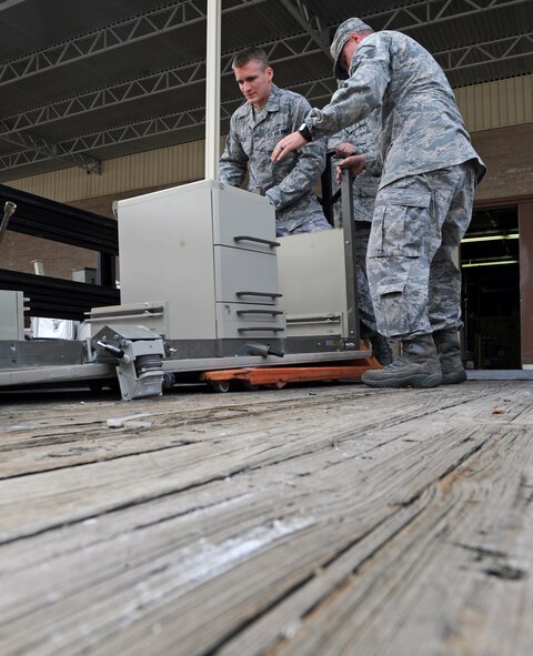 Master Sgt. Denny Shaffer, Tech. Sgt. William Fitzpatrick and Airman 1st Class Vance Besler, 2nd Dental Squadron, move a desk on Barksdale Air Force Base, La., March 14. The desk was removed from the dental lab to make space for renovations. The dental lab will be receiving new desks and equipment to aid them in accomplishing their mission. (U.S. Air Force photo/Airman 1st Class Micaiah Anthony)(RELEASED)
