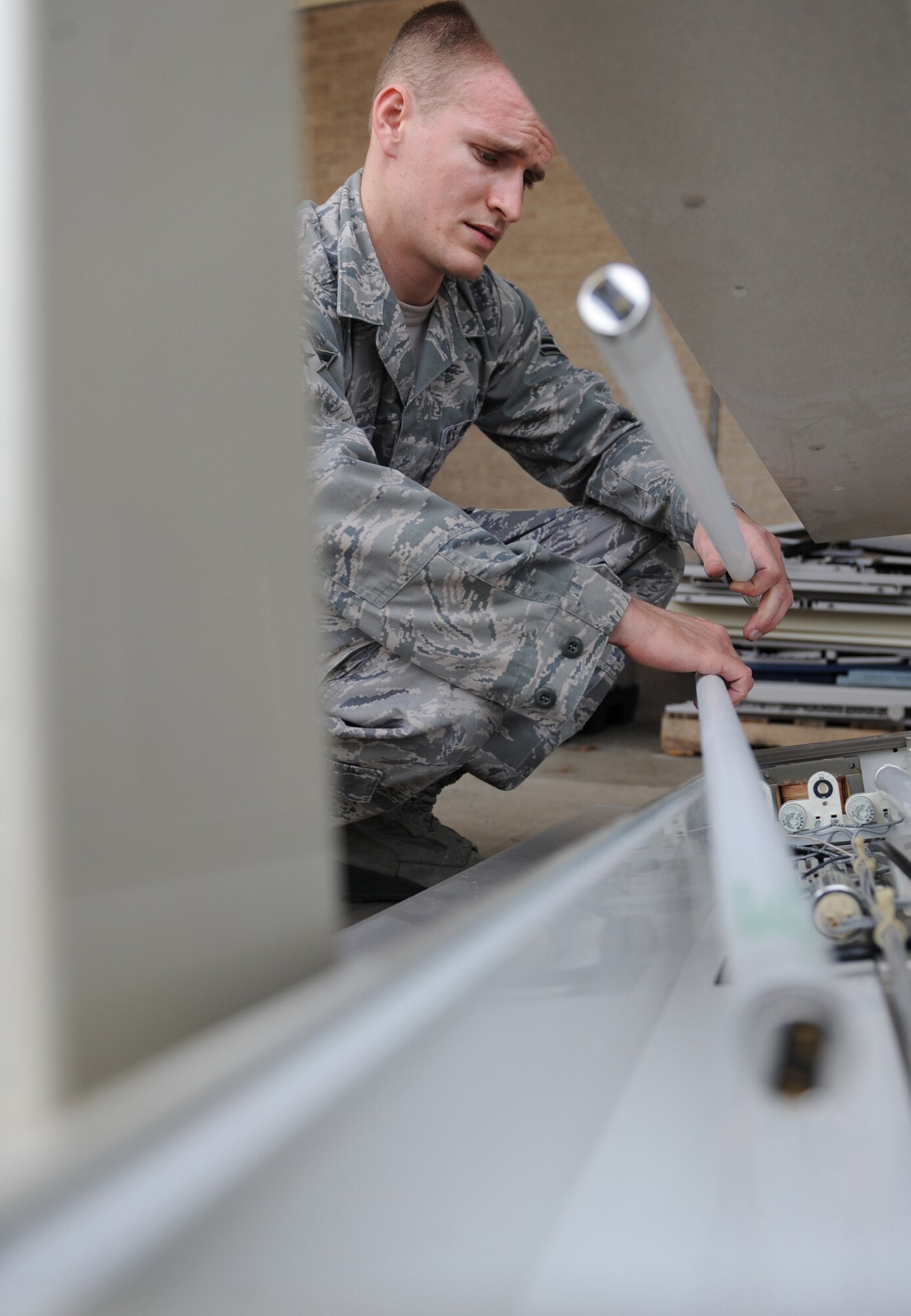 Airman 1st Class Vance Besler, 2nd Dental Squadron, removes light bulbs from a light fixture on Barksdale Air Force Base, La., March 14. Besler assisted dental lab technicians by helping them move equipment in preparation for renovations to be made to the dental lab. (U.S. Air Force photo/Airman 1st Class Micaiah Anthony)(RELEASED)  
