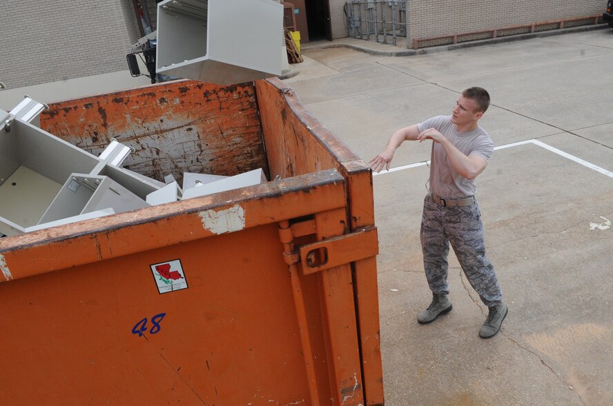 Airman 1st Class Vance Besler, 2nd Dental Squadron, tosses a broken desk piece into a container on Barksdale Air Force Base, La., March 14. Besler assisted dental lab technicians by helping them move equipment in preparation for renovations to be made to the lab. (U.S. Air Force photo/Airman 1st Class Micaiah Anthony)(RELEASED)