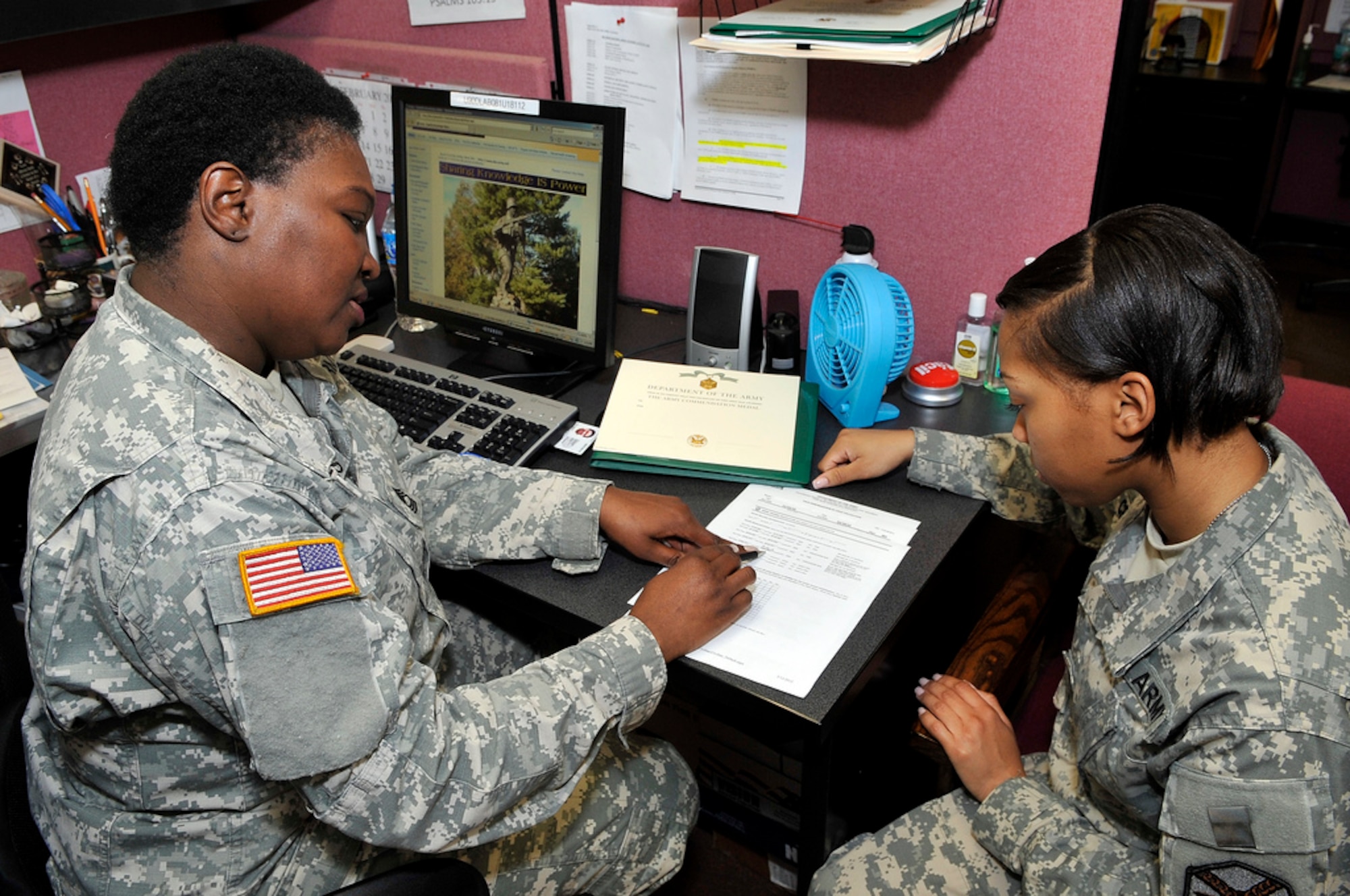 Army Master Sgt. Stephanie Holmes, Army Support Activity-Dix NCO in charge of human resources, assists Spc. Danielle Crawford, with building an award package March 13 here. Holmes is responsible for the over site of all installation level mobilized Soldiers and administrative actions. Holmes said “Taking care of Soldiers is what I do.” (U.S. Air Force photo by Wayne Russell/Released)