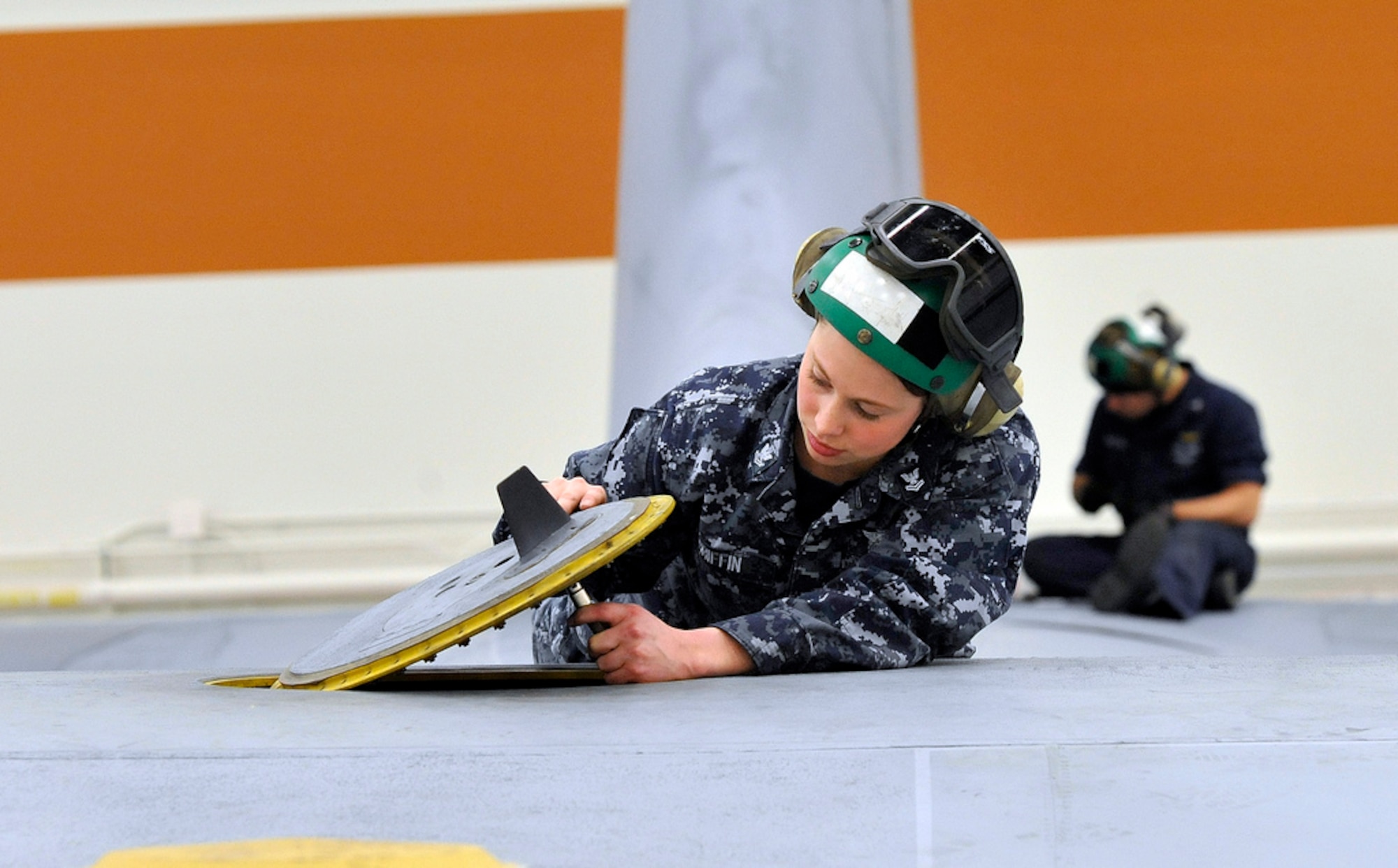 Petty Officer 2nd Class Maria Griffin, VR-64 Fleet Logistics Squadron aviation electronic technician, originally from Lancaster, Ohio, lowers a panel in the flight deck of a C-130 Hercules to check voltage during an aircraft inspection March 9 here. (U.S. Air Force photo by Wayne
Russell/Released)
