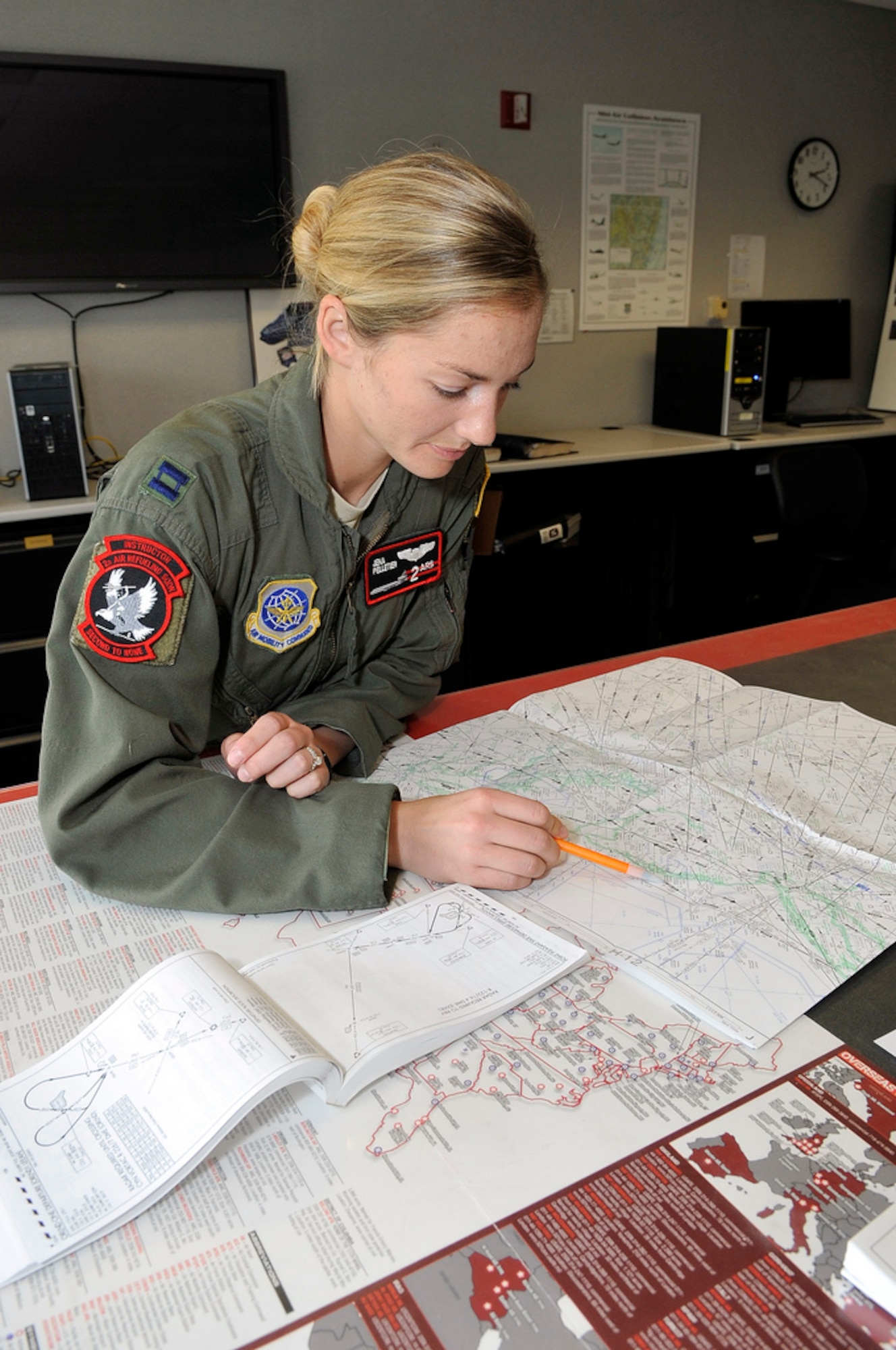 Captain Jena Pelletier, 2nd Air Refueling Squadron KC-10 Extender pilot, originally from Bakersfield, Calif. reviews maps during mission planning in preparation for flight March 13. (U.S. Air Force photo by Wayne Russell/Released)