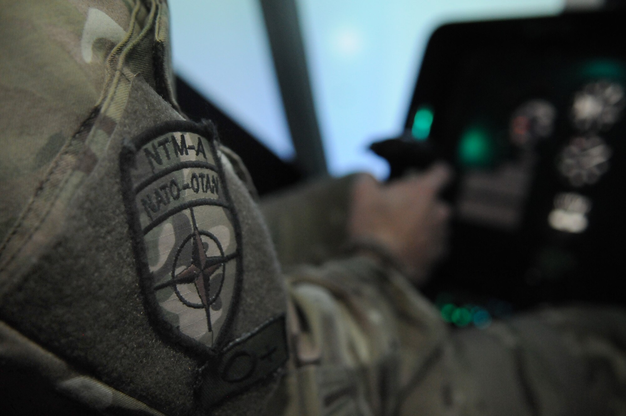 Royal Air Force Flight Lt. Tom Loucaides, 438th Air Expeditionary Wing Thunder Lab director of aviation training, demonstrates a take-off in an Afghan air force Mi-17 helicopter simulator, Kabul International Airport, Afghanistan, March 15, 2012. Loucaides is assigned to the 438th AEW in support of NATO Training Mission-Afghanistan, symbolized by the patch on his right uniform sleeve. (U.S. Air Force photo by Staff Sgt. Nadine Y. Barclay)     
